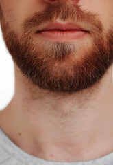 Obraz premium Close up of a young man's beard and mustache, isolated on a white background.