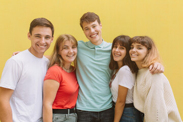 Summer holidays and teenage concept - group of smiling teenagers isolated on a yellow background