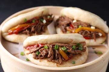Delicious gua bao in bamboo steamer on table, closeup