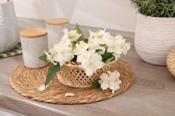 Beautiful jasmine flowers on wooden table indoors