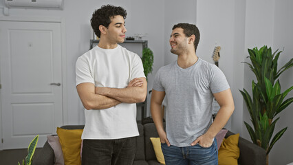 Fototapeta premium Two men smiling and conversing comfortably in a cozy modern living room with decor and plants.