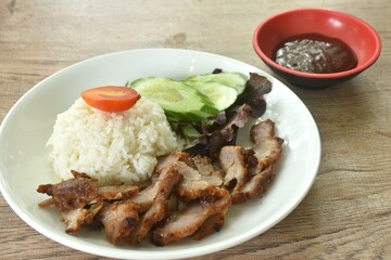 slice grilled fermenting porkwith milk topping rice eat couple cucumber and lettuce dipping spicy barbecue sauce on plate 