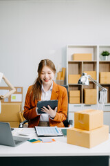 Young business owner woman prepare parcel box and standing check online orders for deliver