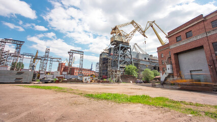 The construction of a large ship on a shipyard with cranes timelapse.