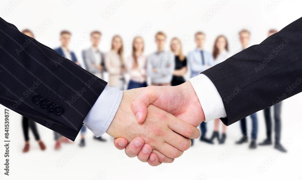 Aufkleber a close-up of a handshake in formal attire with a group of people blurred in the background, depicti