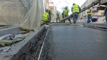 Pouring ready-mixed concrete after placing steel reinforcement to make the road by concrete mixer...