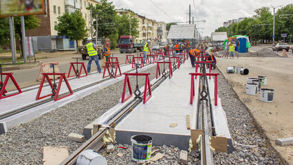 Tram rails at the stage of their installation and integration into concrete plates on the road...