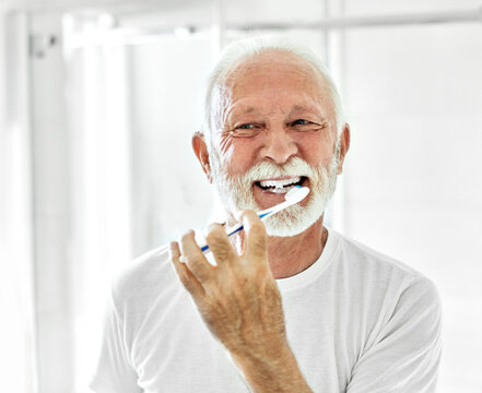 man tooth bathroom toothbrush hygiene senior morning routine brushing toothpaste care dental elderly home retirement mouth mirror health cleaning
