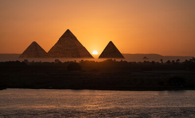 Giza pyramids view from Nile river at amazing sunset - Cairo, Egypt