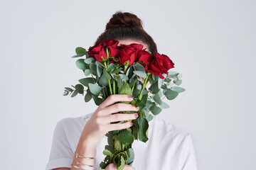 Woman, hands and red roses with bouquet of flowers for floral, anniversary or gift on a white studio background. Female person or model with natural plant, leaves or stem for romance, present or love