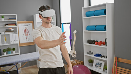 A young hispanic man uses virtual reality in a well-equipped rehabilitation clinic.