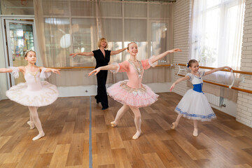 a professional ballet school for children dress rehearsal with dance teacher girls in dresses
