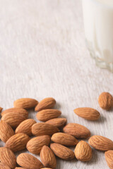Vegan dairy free almond milk and almonds on white wooden background. Selective focus, space for text.