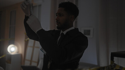 African american detective analyzes evidence at crime scene indoors, male in suit with serious...