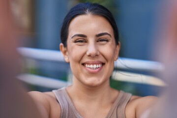 Young beautiful hispanic woman smiling confident making selfie by camera at street