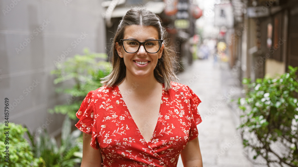 Wall mural Joyful hispanic woman flashing a winning smile on osaka streets