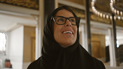 A smiling woman in a hijab inside a mosque, representing the islamic culture of doha, qatar.