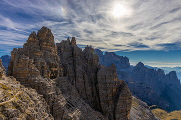 Dolomites beautiful alpine rock tower summits under blue sky in summer. Italian Alps mountains scenic landscape of rocky climbing walls in the high altitude majestic view of the cliff and green valley