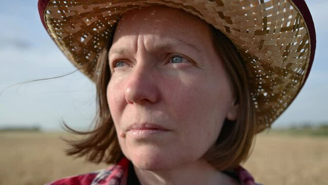Portrait of concerned female farmer in ripe wheat field with dolly zoom vertigo parallax effect