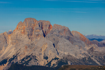 Dolomites beautiful alpine rock tower summits under blue sky in summer. Italian Alps mountains scenic landscape of rocky climbing walls in the high altitude majestic view of the cliff and green valley