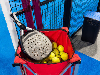 paddle tennis racket and balls on the blue paddle court