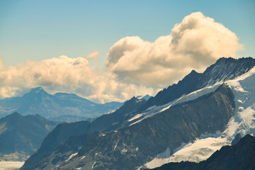 Obraz premium The sky is cloudy and the mountains are covered in snow