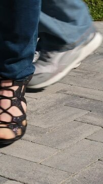Legs of dancing people, black high-heeled dancing shoes and sneakers in jeans, couple dancing. bachata in nature
