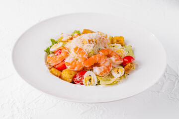 Fresh shrimp caesar salad on white plate