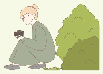 Young woman paparazzi sitting near bushes, making shot by camera. Photographer hiding, taking photos with professional camera, spying outdoors. Hand drawn flat cartoon character vector illustration.