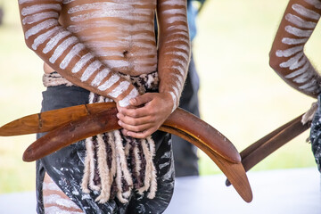 Australian aboriginal ceremony, human hand holds boomerangs for the welcome ritual rite at...