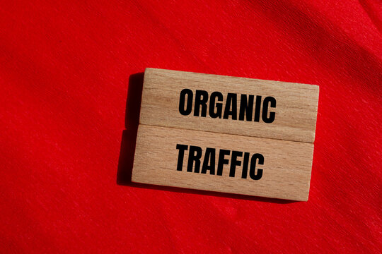 Organic traffic message written on wooden blocks with red background. Conceptual organic traffic symbol. Copy space.