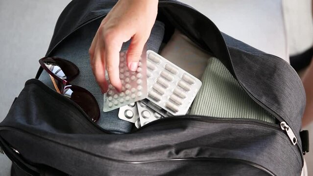 Clothes and pills in a travel bag.  Concept of medication required in journey.