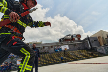 In a dynamic display of synchronized teamwork, firefighters hustle to carry, connect, and deploy...