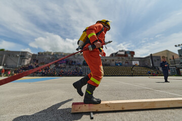 In a dynamic display of synchronized teamwork, firefighters hustle to carry, connect, and deploy...