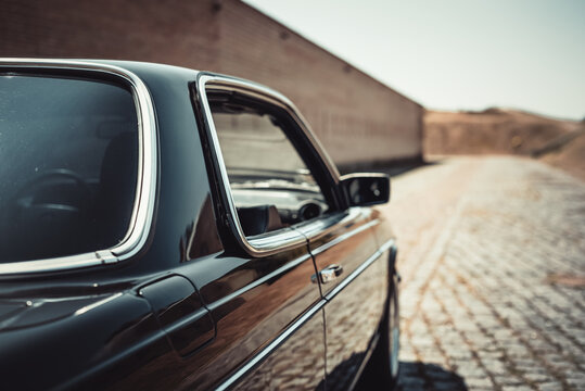 Black classic Mercedes-Benz W123 coupe from 1970s. View from behind of dark old car. Kyiv region, Ukraine - July 18 2015.