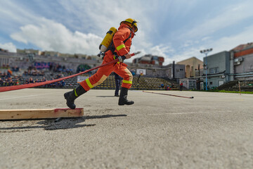 In a dynamic display of synchronized teamwork, firefighters hustle to carry, connect, and deploy...