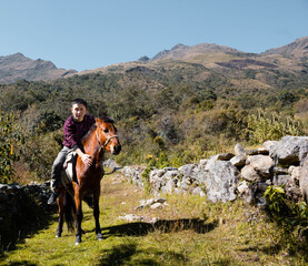 Atractivo joven montado su caballo amando la naturaleza,dia,quechua,estilo de viada viajero,