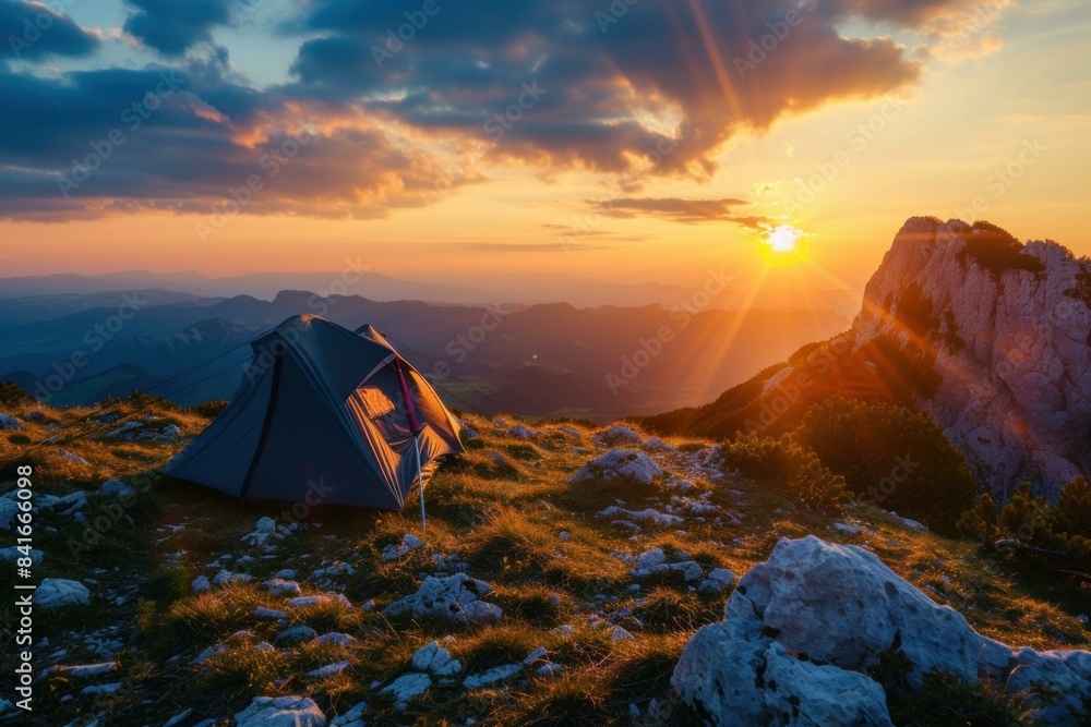 Wall mural Picturesque scene of a tent against a stunning mountainous sunset backdrop