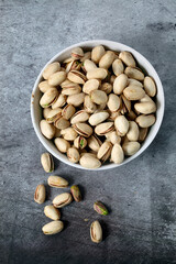 White bowl with unsalted pistachios seen from above