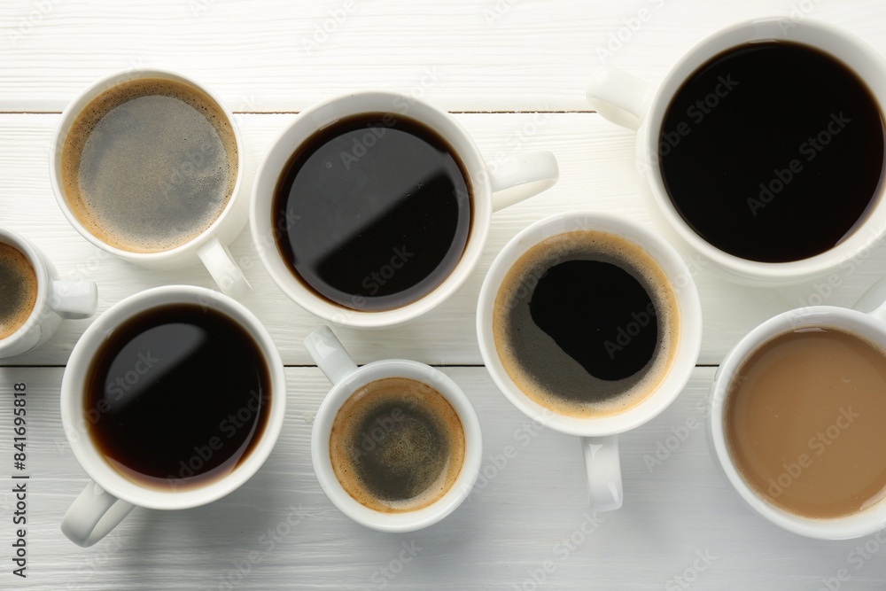 Poster Different coffee drinks in cups on white wooden table, flat lay