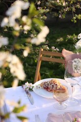 Stylish table setting with beautiful spring flowers in garden
