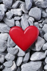Obraz premium Red decorative heart on grey stones, top view