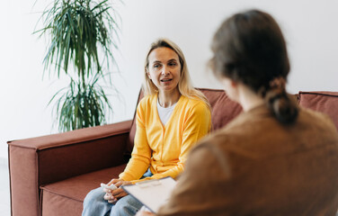 A young woman in a consultation with a professional psychologist listens to advice on improving...