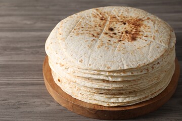 Many tasty homemade tortillas on wooden table
