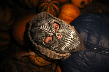 Halloween people. Person in grim reaper mask. Spooky Halloween mask at night. Halloween pumpkins in...