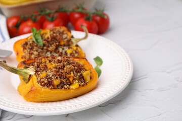 Quinoa stuffed peppers with corn and basil on white textured table