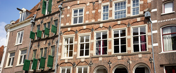 Blue sky behind historic medieval exterior facades of Hanseatic city center Zutphen in The Netherlands against a clear blue sky. Europe tourism destination.