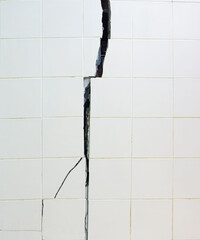 Cracked building structure The concrete wall with tiles was cracked and separated into wide cracks....