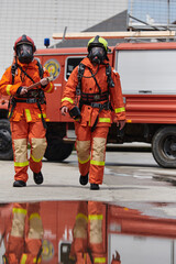 A team of confident and accomplished firefighters strides purposefully in their uniforms, exuding pride and satisfaction after successfully completing a challenging firefighting mission