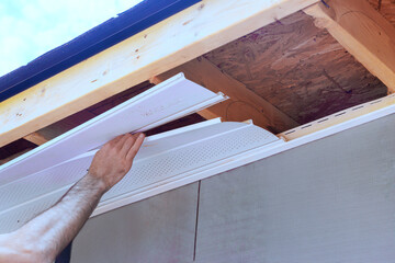 Installation of upvc soffit boards at roof corner of home rafters ceiling © ungvar
